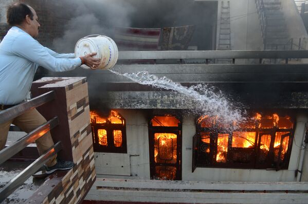 Homem tenta apagar o incêndio em uma loja elétrica na cidade indiana de Amritsar - Sputnik Brasil