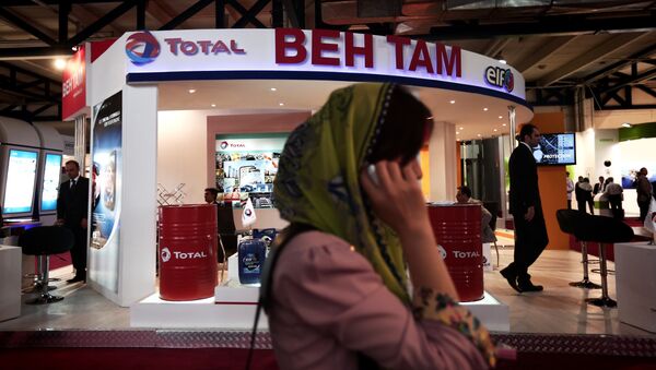 Empresária sul-coreana falando ao telefone em frente à tenda da empresa francesa de óleo e gás Total, durante uma feira internacional de negócios no Irã (foto de arquivo) - Sputnik Brasil