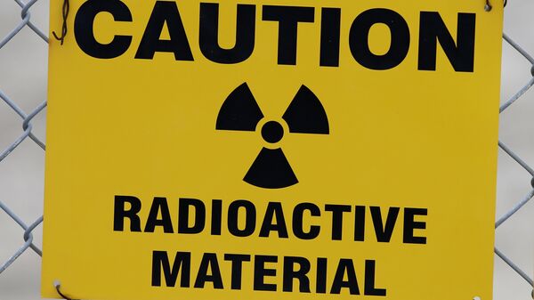 Placa de alerta de radioatividade pendurada na cerca em frente ao prédio que abriga urânio empobrecido nas instalações da EnergySolutions em Clive, Utah, EUA, 6 de meio de 2015. - Sputnik Brasil
