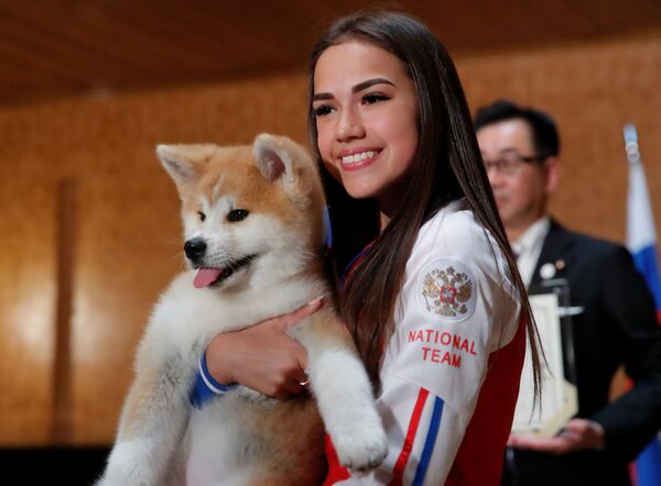 Patinadora artística e campeã olímpica russa, Alina Zagitova, posa com cachorrinho da raça Akita Inu que lhe foi presenteado pela delegação japonesa, em Moscou - Sputnik Brasil