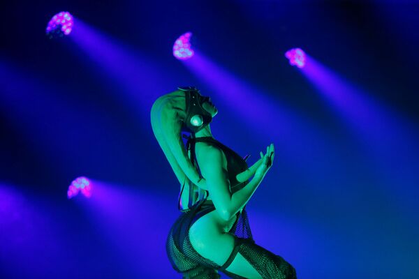 Dançarina em traje especial se apresenta no palco em Los Angeles iluminada por luzes suaves - Sputnik Brasil