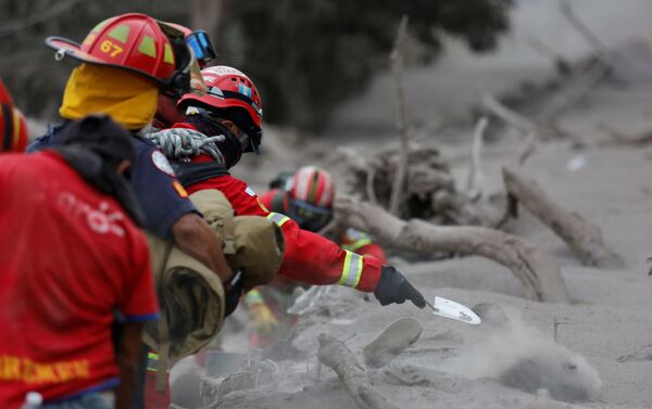 Equipes de resgate cavam a procura de corpos após a erupção do vulcão Fogo na Guatemala, em 4 de junho de 2018 - Sputnik Brasil