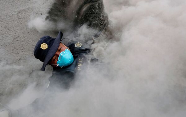 Policial tropeça enquanto foge das novas emissões de cinzas do vulcão Fogo, Guatemala, em 4 de junho de 2018 - Sputnik Brasil