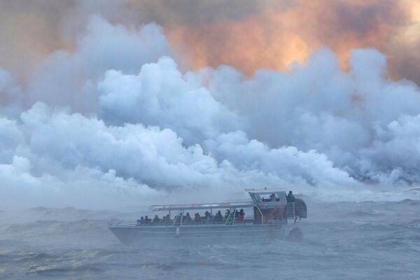 Pessoas olhando desde um barco a lava correndo ao oceano Pacífico durante as erupções do vulcão Kilauea, no Havaí. - Sputnik Brasil