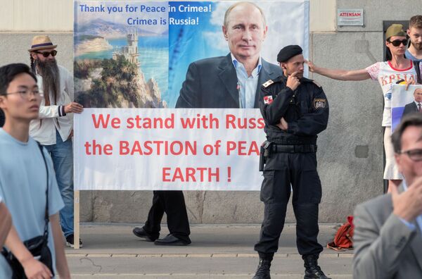 Austríacos segurando um cartaz com a imagem de Vladimir Putin durante seu encontro com o presidente da Áustria Alexander van der Bellen, em Viena. - Sputnik Brasil