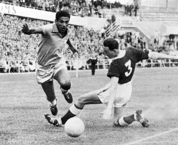Garrincha dribla o zagueiro do galês Mel Hopkins durante partida de futebol da Copa do Mundo entre Brasil e País de Gales em 19 de junho de 1958, em Gotemburgo. O Brasil avançou para as semifinais com uma vitória de 1 a 0 sobre o gol de Pelé, então com 17 anos. - Sputnik Brasil