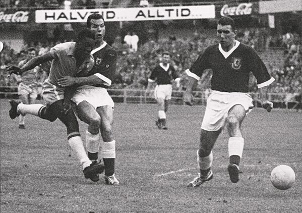 O atacante Pelé, de 17 anos, dribla dois zagueiros do País de Gales durante a partida de futebol das quartas de final da Copa do Mundo entre Brasil e País de Gales em 19 de junho de 1958, em Gotemburgo. Pelé marcou o único gol da partida para ajudar o Brasil a avançar para as semifinais. - Sputnik Brasil