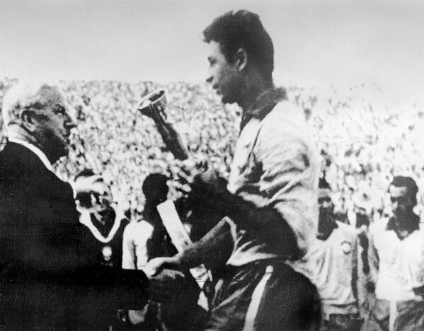 O presidente da Federação Internacional de Futebol (FIFA), o inglês Stanley Rous, parabeniza o capitão da seleção brasileira, Mauro, depois de entregar a Taça Jules Rimet em 17 de junho de 1962, em Santiago, após a vitória do Brasil sobre a Tchecoslováquia (3 a 1). - Sputnik Brasil