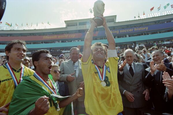 O capitão brasileiro Dunga levanta o troféu da Copa do Mundo da FIFA 1994 ao lado de Romário, após o Brasil derrotar a Itália por 3 a 2 nos pênaltis. O italiano Roberto Baggio perdeu o pênalti e deu ao Brasil o seu quarto título mundial. - Sputnik Brasil