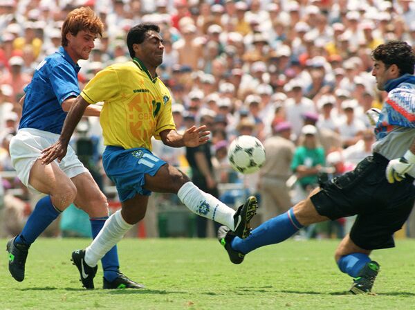 O atacante brasileiro Romário passa pelo zagueiro italiano Luigi Apolloni enquanto tenta chutar a bola sobre o goleiro Gianluca Pagliuca, em 17 de julho de 1994, durante a final da Copa do Mundo. - Sputnik Brasil