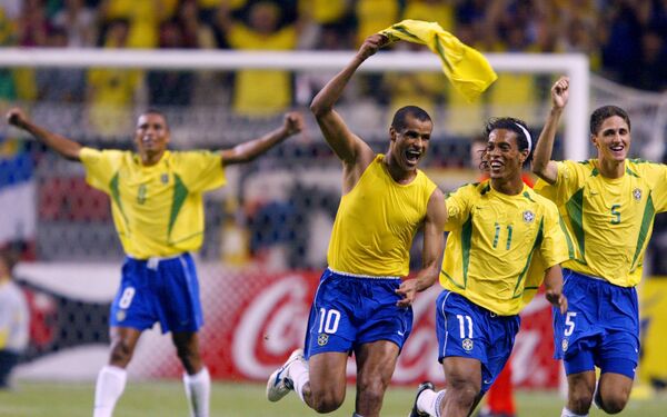 O meia brasileiro Rivaldo comemora com o zagueiro brasileiro Edmilson, o meio-campista Ronaldinho Gaúcho e Gilberto Silva após marcar um gol  durante partida do Brasil contra Bélgica na Copa do Mundo de 2002 no Japão. - Sputnik Brasil
