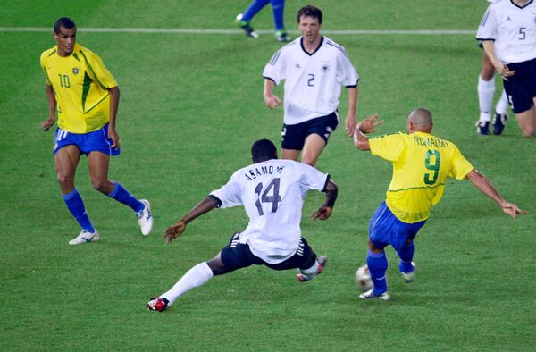 O meia brasileiro Rivaldo e o zagueiro alemão Thomas Linke assistem o atacante da Alemanha Gerald Asamoah tentar impedir o atacante Ronaldo de marcar seu segundo gol durante a final da Copa do Mundo de 2002. O Brasil venceu a final por 2-0. - Sputnik Brasil