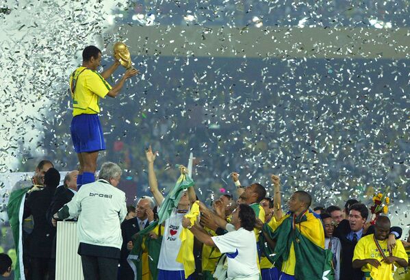 O capitão e zagueiro do Brasil Cafu levanta o troféu da Copa do Mundo sobre seus companheiros comemorando a vitória do Brasil por 2 a 0 sobre a Alemanha na final da Copa do Mundo de 2002 no Estádio Internacional Yokohama, Japão. - Sputnik Brasil