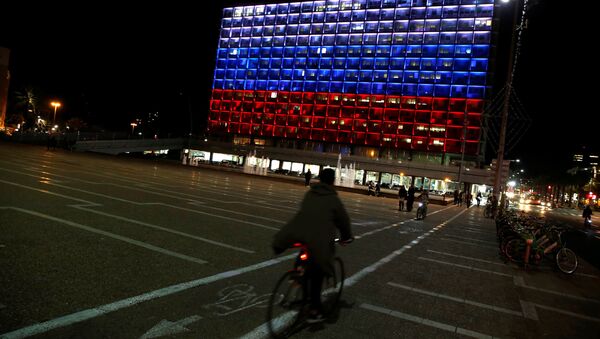 A man rides bicycle across the Tel Aviv city hall building as it is illuminated in solidarity with Russia after the blast in the St.Petersburg metro in Tel Aviv, Israel April 3, 2017 - Sputnik Brasil