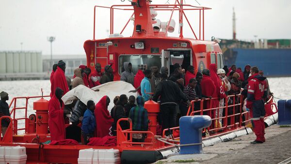 Migrants, who were part of a group intercepted aboard a dinghy off the coast in the Mediterranean sea, stand on a rescue boat upon arriving at a port in Malaga, southern Spain, December 3, 2016 - Sputnik Brasil