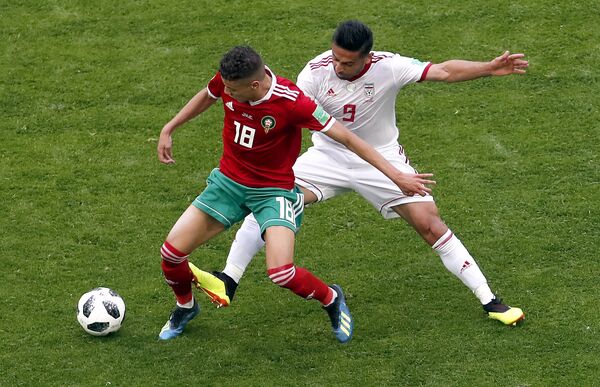 Amine Harit, do Marrocos, e Omid Ebrahimi, do Irã, dividem a bola. - Sputnik Brasil