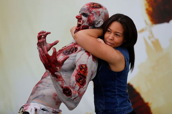 Menina faz uma foto com zombie na feira de videogames e jogos eletrônicos em Los Angeles - Sputnik Brasil
