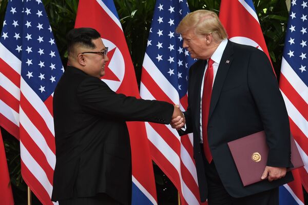 O presidente norte-americano Donald Trump aperta a mão do líder norte-coreano Kim Jong-um, na cúpula entre os EUA e a Coreia do Norte, em Singapura - Sputnik Brasil