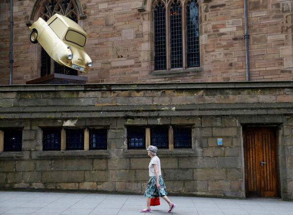 Uma mulher passa pela instalação 'Gold Lamé' do artista Tony Heaton, em Liverpool - Sputnik Brasil