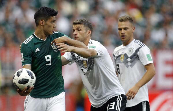 O jogador alemão Thomas Mueller tenta tomar a bola do mexicano Raul Jimenez durante jogo entre as seleções no 1º jogo do grupo F da Copa do Mundo de 2018. - Sputnik Brasil
