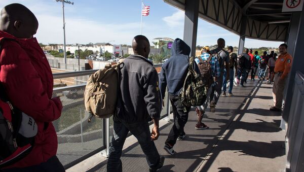 Migrantes haitianos que procuram asilo nos Estados Unidos fazem fila frente a um prédio na fronteiriça cidade mexicana de Tijuana. - Sputnik Brasil
