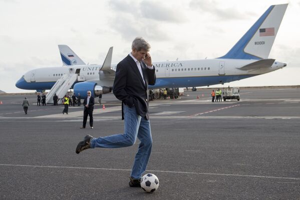 Secretário de Estado John Kerry chutando bola enquanto fala pelo celular durante paragem para reabastecimento do avião em Cabo Verde, 2014 - Sputnik Brasil