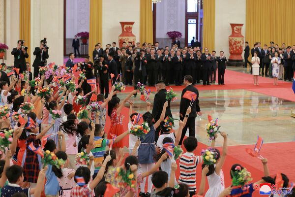Crianças oferecem flores, cumprimentando os líderes chinês e norte-coreano em Pequim - Sputnik Brasil
