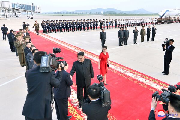 O líder da Coreia do Norte, Kim Jong-un, e sua esposa, Ri Sol-ju, caminham no tapete vermelho em Pequim no âmbito da visita oficial - Sputnik Brasil