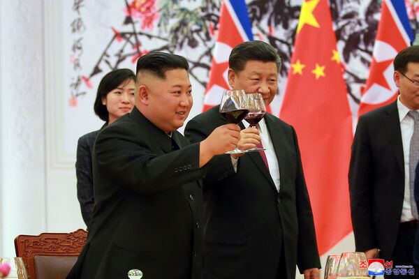 O presidente da China, Xi Jinping, e o líder da Coreia do Norte, Kim Jong-un, levantam taças durante o encontro oficial em Pequim - Sputnik Brasil
