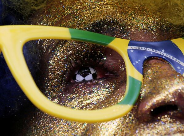 Torcedor brasileiro, em São Paulo, assiste ao jogo Brasil x Costa Rica, pela Copa do Mundo. Ele usa uma lente em formato de bola de futebol. - Sputnik Brasil