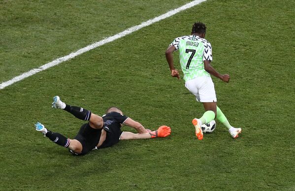 Ahmed Musa, da Nigéria, deixa no chão o goleiro Hannes Halldorsson, que já parou Lionel Messi nesta Copa do Mundo, para marcar um dos gols da vitória nigeriana por 2x0. - Sputnik Brasil