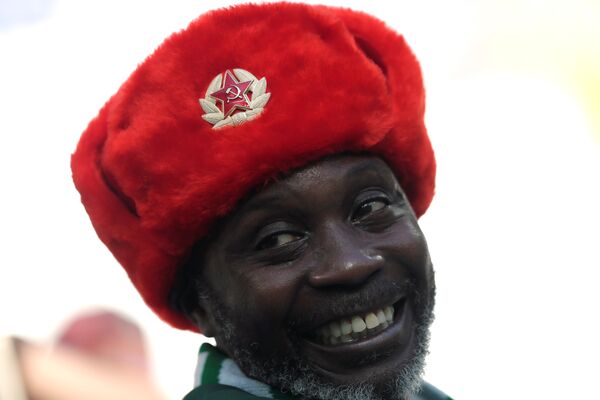 Torcedor nigeriano sorri com um gorro soviético enquanto assiste a seleção da Nigéria vencer a Islândia por 2x0 em Volgogrado durante a Copa do Mundo. - Sputnik Brasil