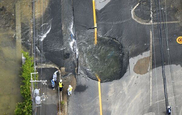 Água saindo de um buraco em uma estrada danificada por terremoto em Takatsuki, Japão. - Sputnik Brasil