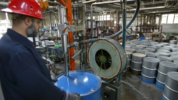 Trabalhador da refinaria de Dura, próximo a Bagdá, enche um barril de petróleo. - Sputnik Brasil