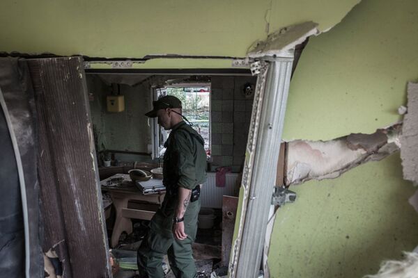 Membro das milícias populares da República Popular de Donetsk visita uma casa destruída pelos militares ucranianos em Gorlovka. - Sputnik Brasil
