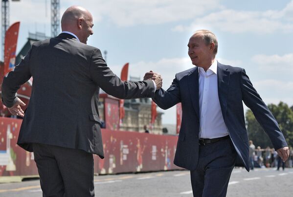 O Presidente da Rússia, Vladimir Putin, e o presidente da FIFA, Gianni Infantino, apertam mãos durante um passeio pelo parque de futebol instalado na Praça Vermelha, bem no centro de capital russa - Sputnik Brasil