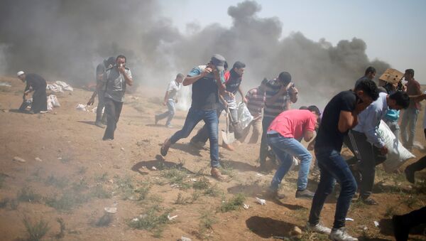 Manifestantes palestinos correm de gás lacrimogêneo disparado por tropas israelenses durante um protesto que marca o Dia de Al-Quds, (Dia de Jerusalém), na fronteira entre Israel e Gaza. - Sputnik Brasil