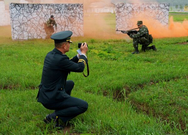 Militar sul-coreano tira fotos de soldados durante exercícios militares no campo de treinamento Sergeevsky na região russa de Primorie - Sputnik Brasil