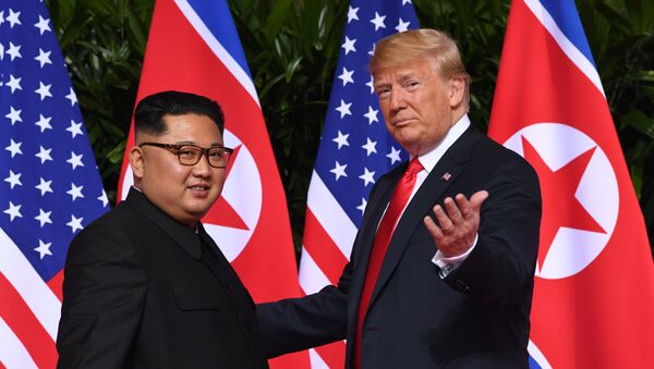 US President Donald Trump (R) gestures as he meets with North Korea's leader Kim Jong Un (L) at the start of their historic US-North Korea summit, at the Capella Hotel on Sentosa island in Singapore on June 12, 2018. - Sputnik Brasil