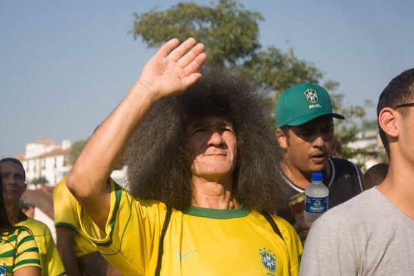 Torcedor tenta tapar o sol para assistir ao jogo do Brasil contra a Bélgica na Copa do Mundo de 2018. - Sputnik Brasil