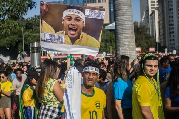 Vendedor de faixas 100% Jesus carrega placa com o rosto de Neymar. - Sputnik Brasil