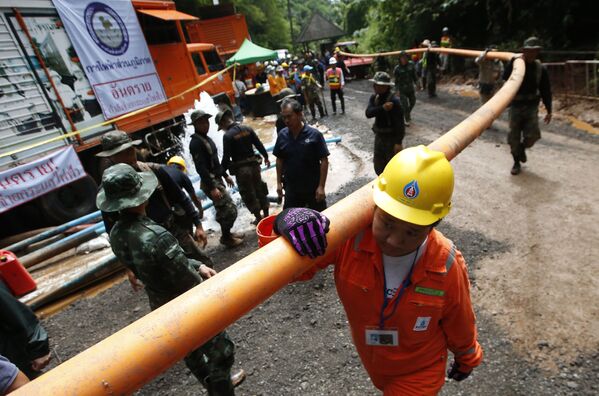 Homens segurando um tubo de adutora durante a operação de resgate das crianças em gruta na Tailândia - Sputnik Brasil