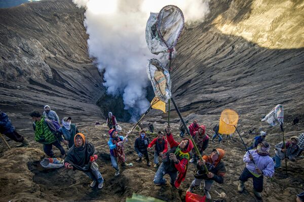 Pessoas se preparando para pegar oferendas atiradas por representantes da tribo Tengger no vulcão ativo Mount Bromo para celebrar o Festival Hindu Yadnya - Sputnik Brasil