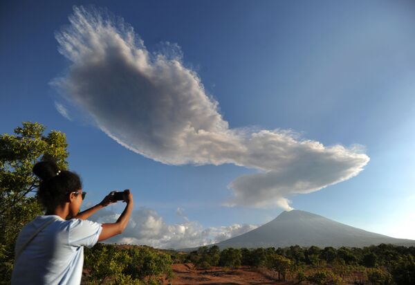 Mulher fotografando fumaça de vulcão na ilha indonésia de Bali - Sputnik Brasil