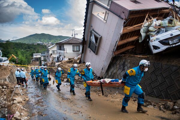 Bombeiros e policiais junto às moradias desmoronadas na sequência de aguaceiros fortes no Japão - Sputnik Brasil