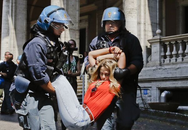 Policiais arrastam uma manifestante perto do edifício do Ministério de Transportes em Roma, na Itália - Sputnik Brasil