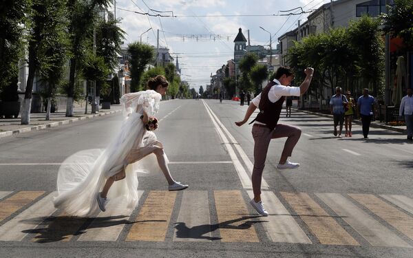 Recém-casados posam para foto ao atravessar a estrada durante a Copa 2018 em Samara, na Rússia - Sputnik Brasil