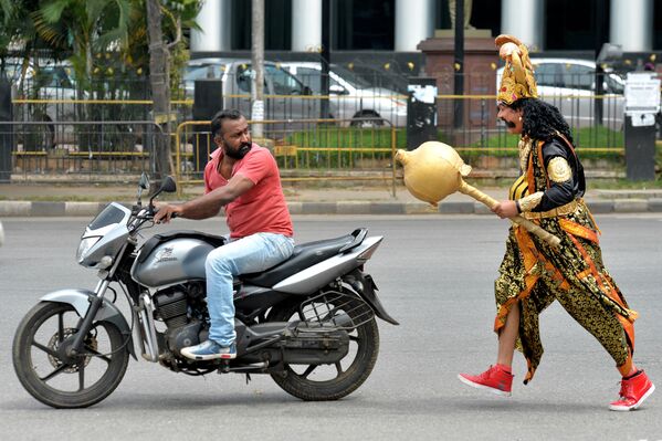 Artista vestido de deus da morte hinduísta Enma, junto a um motoqueiro, na Índia - Sputnik Brasil