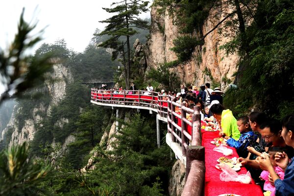 Turistas durante um banquete organizado à beira de uma falésia, na China - Sputnik Brasil