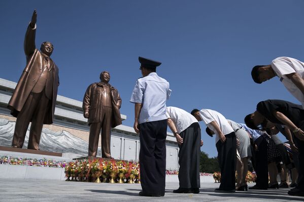 Cidadãos norte-coreanos prestam homenagem às estátuas dos líderes Kim Il-sung e Kim Jong-il, em Pyongyang - Sputnik Brasil